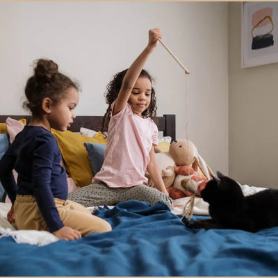 enfants jouant avec leur chat avec leur mère qui regarde 