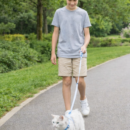 garçon qui tient son chat en laisse dehors